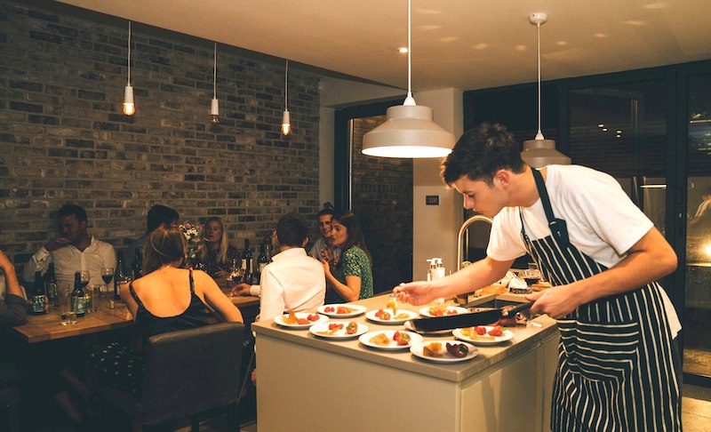 Picture of a dinner party with Jojo from Nomad Cooks as the evening's chef
